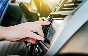 Adjusting Prints: Close up of hands changing the car radio station