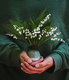 Kingston Prints: Close up of hands holding a small vase of lily of the valley flowers