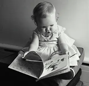 Beginnings Prints: Close-up of a baby girl holding a picture book