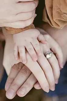 Parenting Prints: Close-up of baby hand resting on parents hands with wedding ring