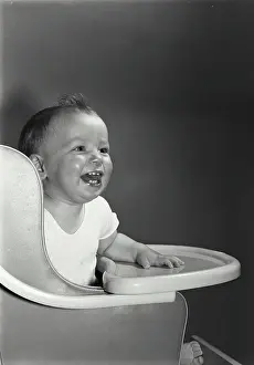 Innocence Prints: Close-up of a baby laughing in a high chair