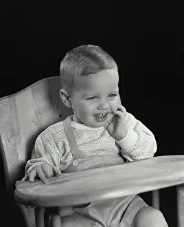 Overalls Prints: Close-up of a baby sitting in a high chair and smiling