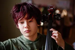 Focused Prints: Close-up of serious boy with dyed red hair practicing cello music