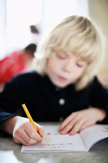 Instruction Prints: Close-up on boy's writing in book