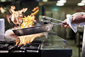 Chef Prints: Close-up of chef's hands holding a sauté pan to cook food