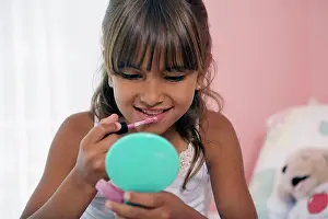 One Child Only Prints: Close-up of a girl applying lipstick