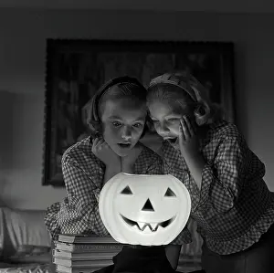 Short Prints: Close-up of two girls looking at an illuminated jack o lantern