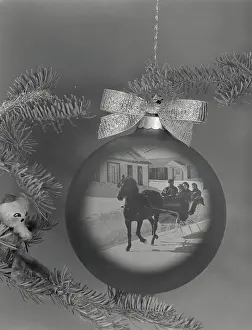 Mixed Prints: Close-up of a horsedrawn sleigh superimposed on a Christmas ornament