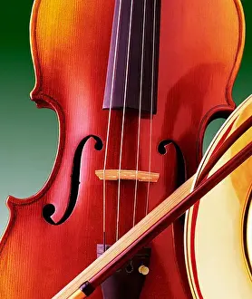 Instrument Prints: Close-up still life of a violin and a bow resting against the bell of a horn