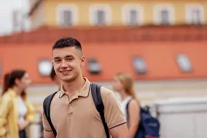 Nahaufnahme Prints: Close-up of a male portrait of a cute guy in a beige T-shirt with a black backpack