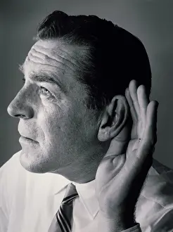 Listening Prints: Close-up of a mature man with a cupped hand to his ear