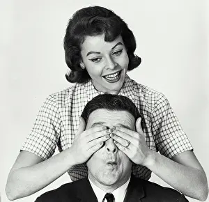 Shirt And Tie Prints: Close-up of a mid adult woman covering a mid adult man's eyes