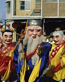 City Location Prints: Close-up of three people wearing masks and costumes in a traditional festival