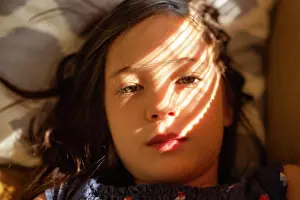 Shadows Prints: close-up portrait of beautiful girl laying in dappled window light