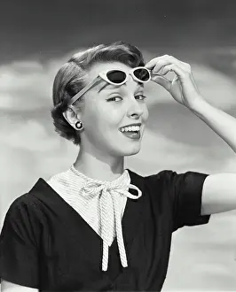 Lifting Prints: Close-up of young woman holding sunglasses