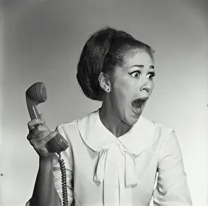 Facial Expression Prints: Close-up of a young woman holding a telephone receiver and shouting
