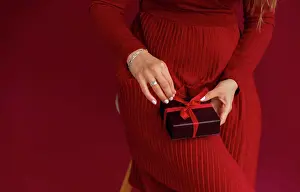 Opening Prints: Close up of woman in red dress opened box with stripe