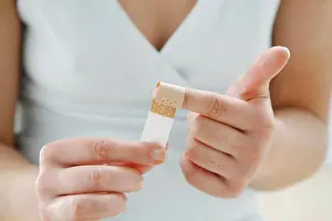 Upper Body Prints: close up - young woman is wraping a plaster around her index finger- band-aid
