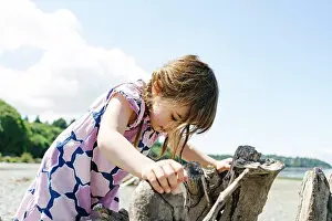Curiosity Prints: Closeup view of a young girl climbing on driftwood at Carkeek Park
