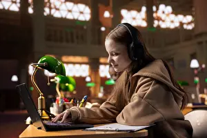 Notes Prints: College student listening to study music on headphones to create the perfect ambient for research