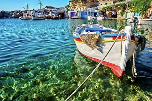 Out Of Focus Prints: Colorful authentic Greek fishing boats anchored in a small village in crystal clear sea waters