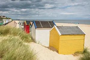 Sand Dune Prints: Colourful beach huts pictured behind dune grass at the end of the promenade at Southwold beach on the Suffolk coast