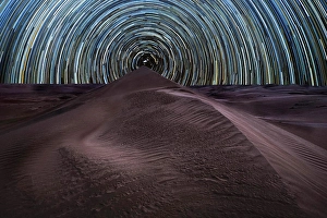 Dramatic Sky Prints: Concentric circumpolar star trail above sand dunes in the Rub al Khali desert