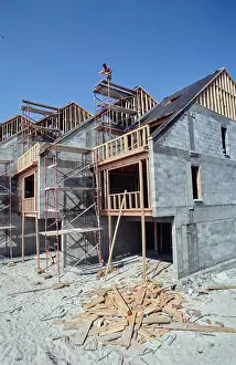 Brickwork Prints: Construction progress on new residential homes under clear blue skies