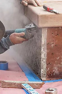 Dusty Prints: Construction worker using grinder at construction site