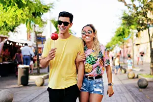 Fondness Prints: Content couple having fun walking on street in fair