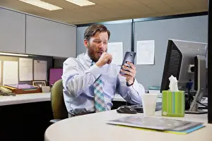 Fever Prints: coughing young Caucasian man working in cubicle at office