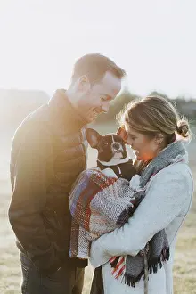 Networks Prints: Couple carrying their puppy in woollen blanket