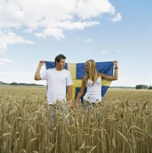 Summers Prints: Couple holding Swedish flag in field