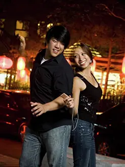 Consumer Electronics Prints: Couple listening to mp3 player outdoors dancing and smiling