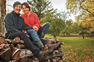 Holding Hands Prints: A couple sitting on pile of split firewood