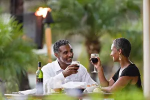 50 To 55 Years Prints: Couple toasting each other at dinner