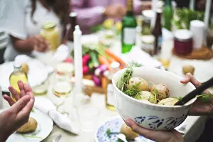 Youngmen Prints: Cropped image of woman holding boiled potatoes bowl at dining table during dinner party