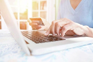 Worldwide Web Prints: Cropped view of woman holding credit card using laptop