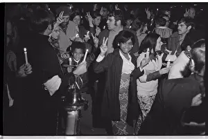 Marching Prints: Crowd of people flashing Peace signs and holding candles