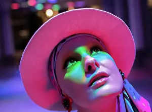 Curiosity Prints: Curious stylish woman in pink hat looking up in neon light