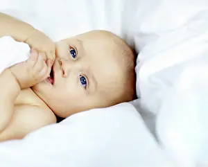 Curiosity Prints: Cute, development and growth with baby in bed of nursery for curiosity