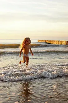 Unwind Prints: Cute girl wearing underwear playing in water on beach