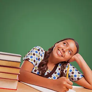 Descent Prints: Cute hispanic girl studying and looking up to blank chalk board