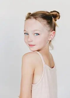 Gradeschooler Prints: cute little girl looking over her shoulder, white background