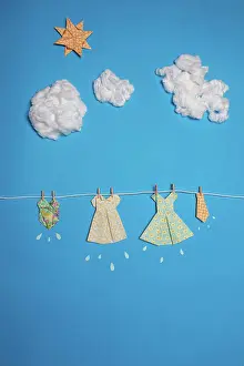 Apparel Prints: Cute paper dresses attached to rope against blue sky with clouds