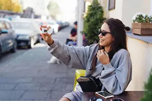 Staedtisch Prints: Cute, young female blogger posing on camera