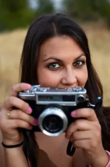 One Young Woman Only Prints: Cute young woman using old camera
