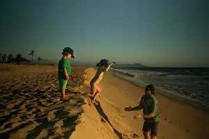 Small Group Prints: A dad catches his daughter jumping down a steep beach
