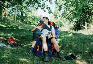 People In Nature Prints: dad hugging his son whilst camping in the sunshine on vacation