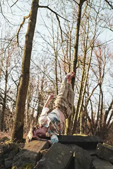Flanders Prints: dancer balances in strong hold on stones in winter forrest